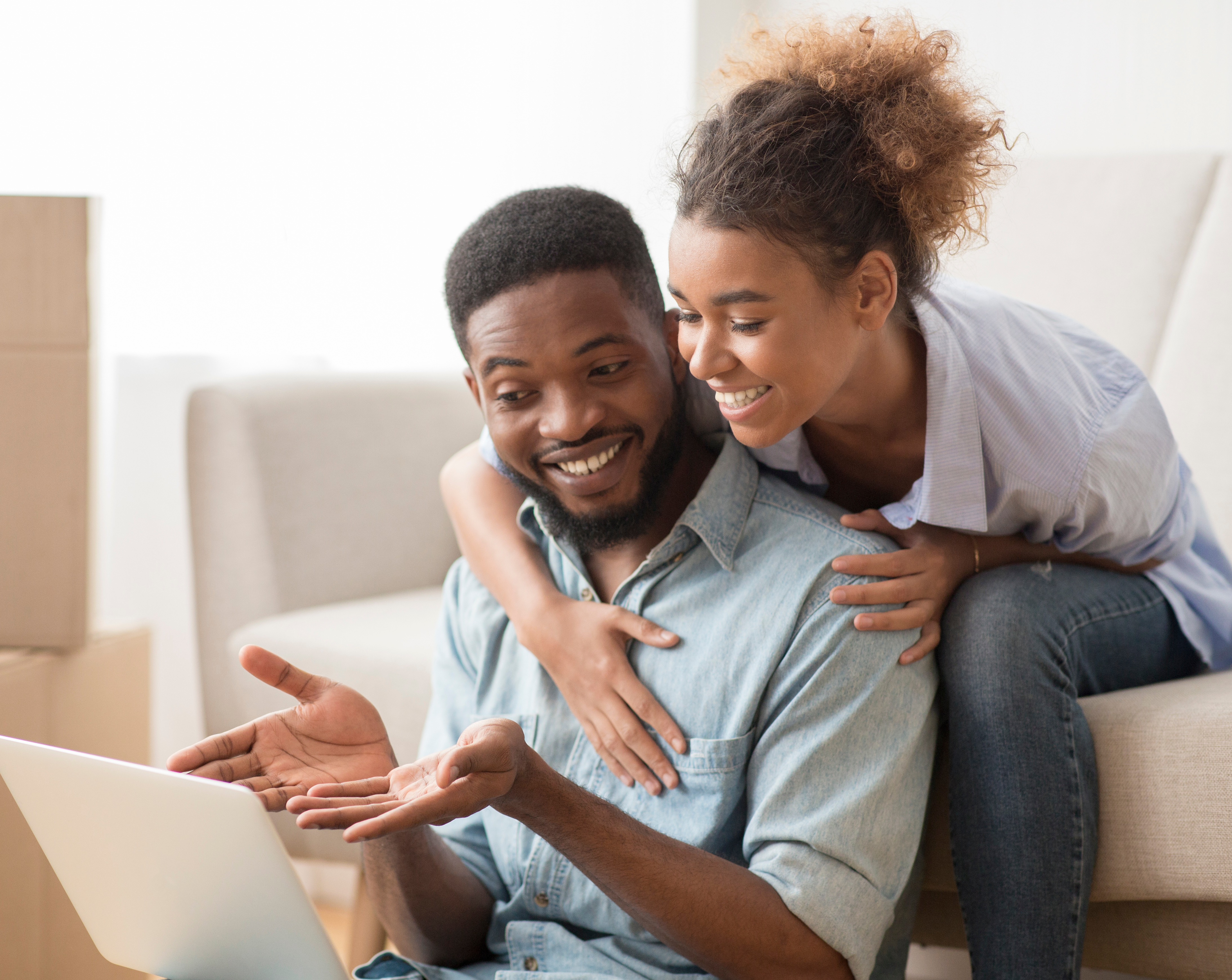 Black man and woman looking at available properties on a laptop
